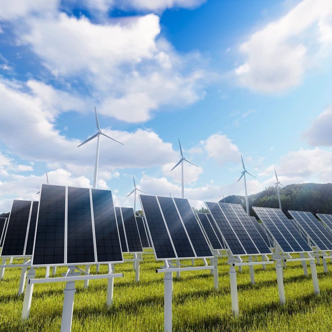 A field with many solar panels and wind mills.